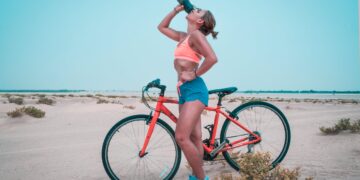 meisje op fiets drinkt water