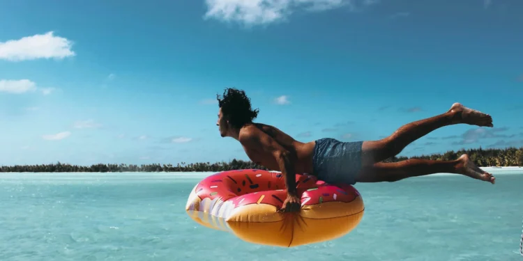 man die in het water springt met een band